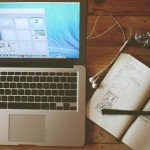 Picture of Apple laptop, writing tool, and paper notebook