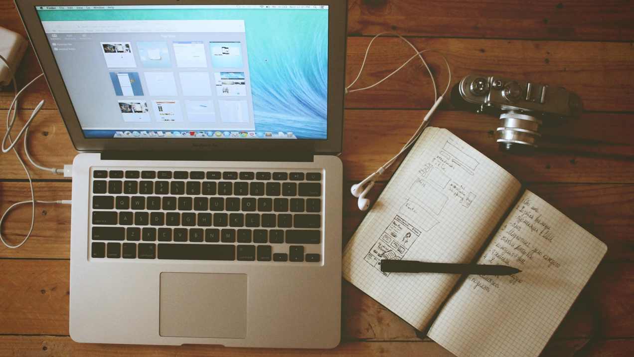 Picture of Apple laptop, writing tool, and paper notebook